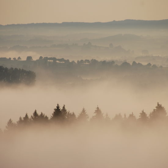 In de deken van watten verschijnen de bergketens in de verte.