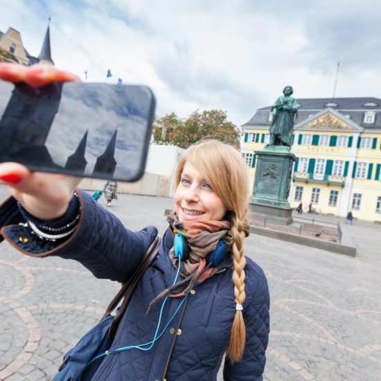 Meisje maakt een selfie voor het beeld van Van Beethoven in Bonn