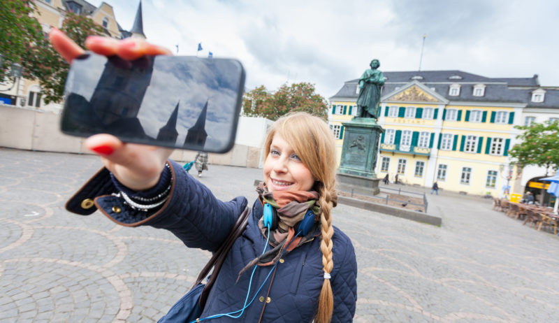 Meisje maakt een selfie voor het beeld van Van Beethoven in Bonn