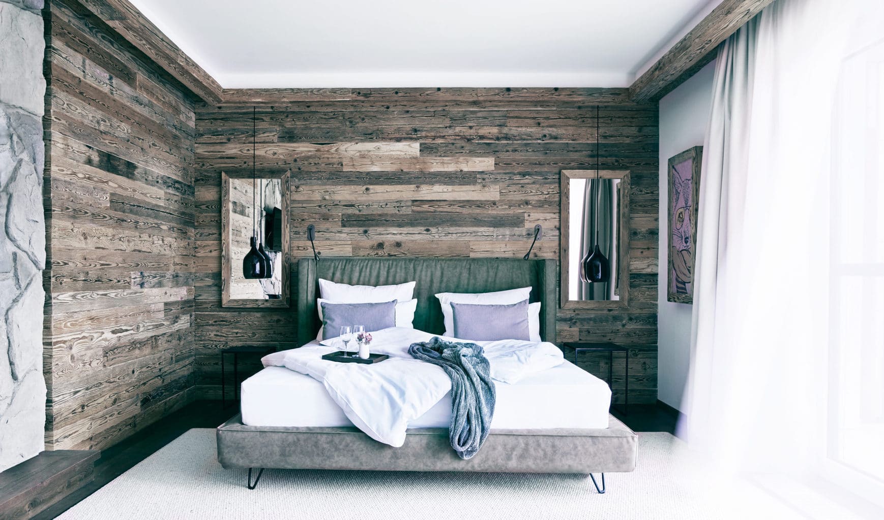 Tweepersoonskamer met houten bed in een suite van Landgut Voshövel aan de Nederrijn