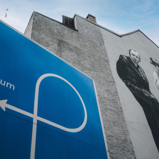 Graffiti met kunstenaar Joseph Beuys en een bord dat wijst naar de ingang van een museum in Mönchengladbach