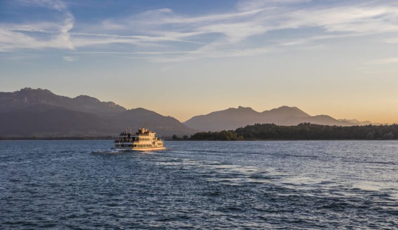 Een boot van de Chiemsee Schifffahrt op het meertje voor de bergen