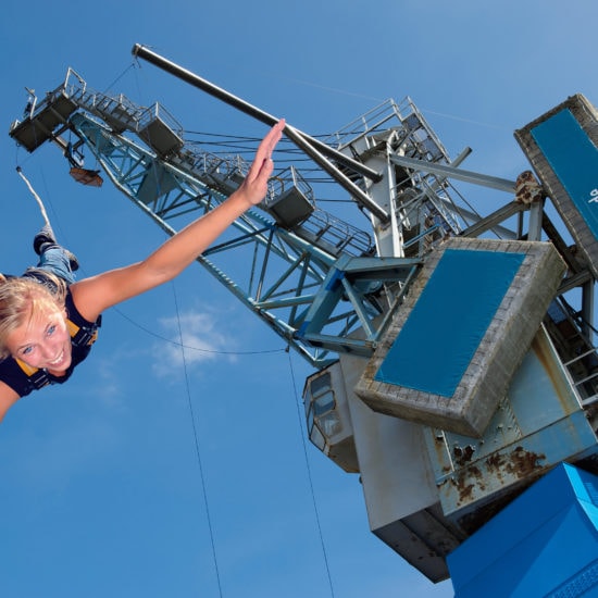 Een vrouw tijdens het bungee jumpen aan een havenkraan in Hamburg