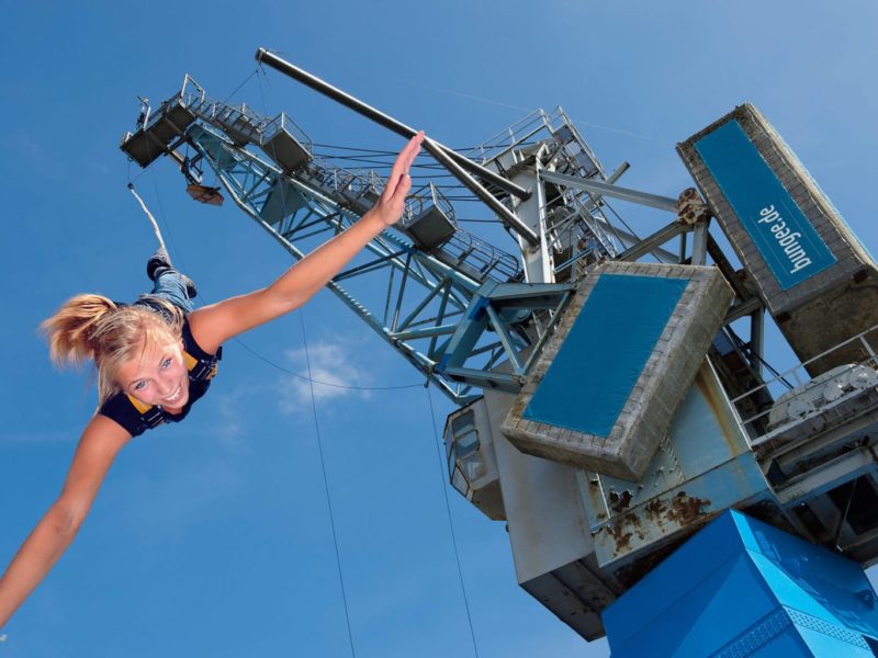 Een vrouw tijdens het bungee jumpen aan een havenkraan in Hamburg