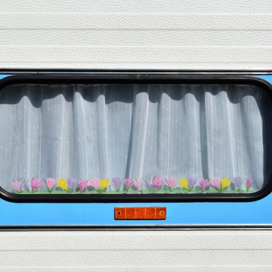 De ruit van een woonwagen of campervan met gesloten gordijn, de leukste Duitse camping aan het water