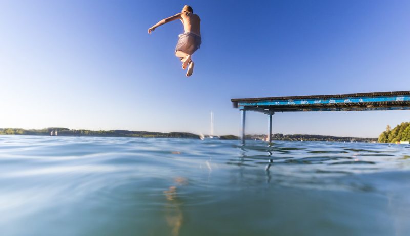 Jongen springt het water in