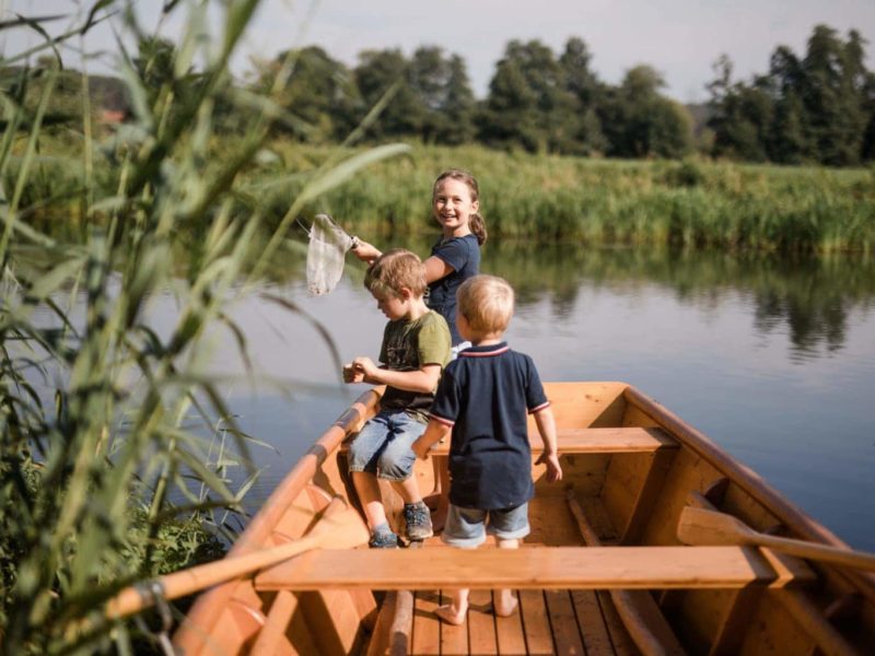 Kinderen spelen in een boot op het water bij een van de vakantieboerderijen in Beieren