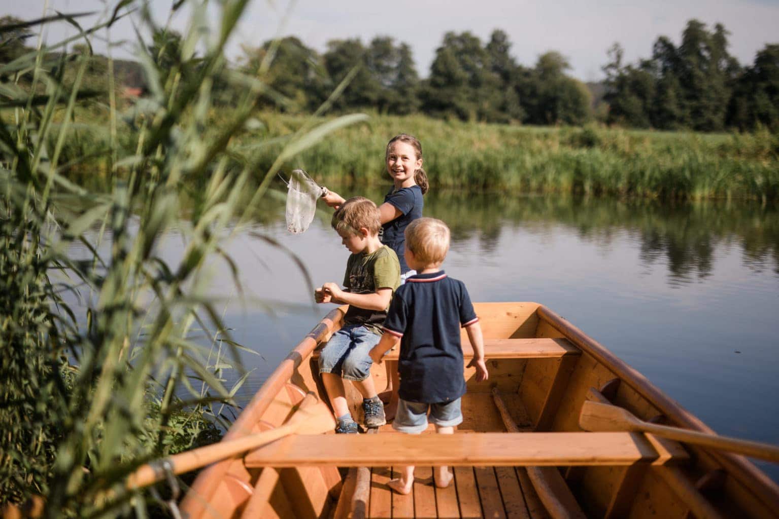Kinderen spelen in een boot op het water bij een van de vakantieboerderijen in Beieren