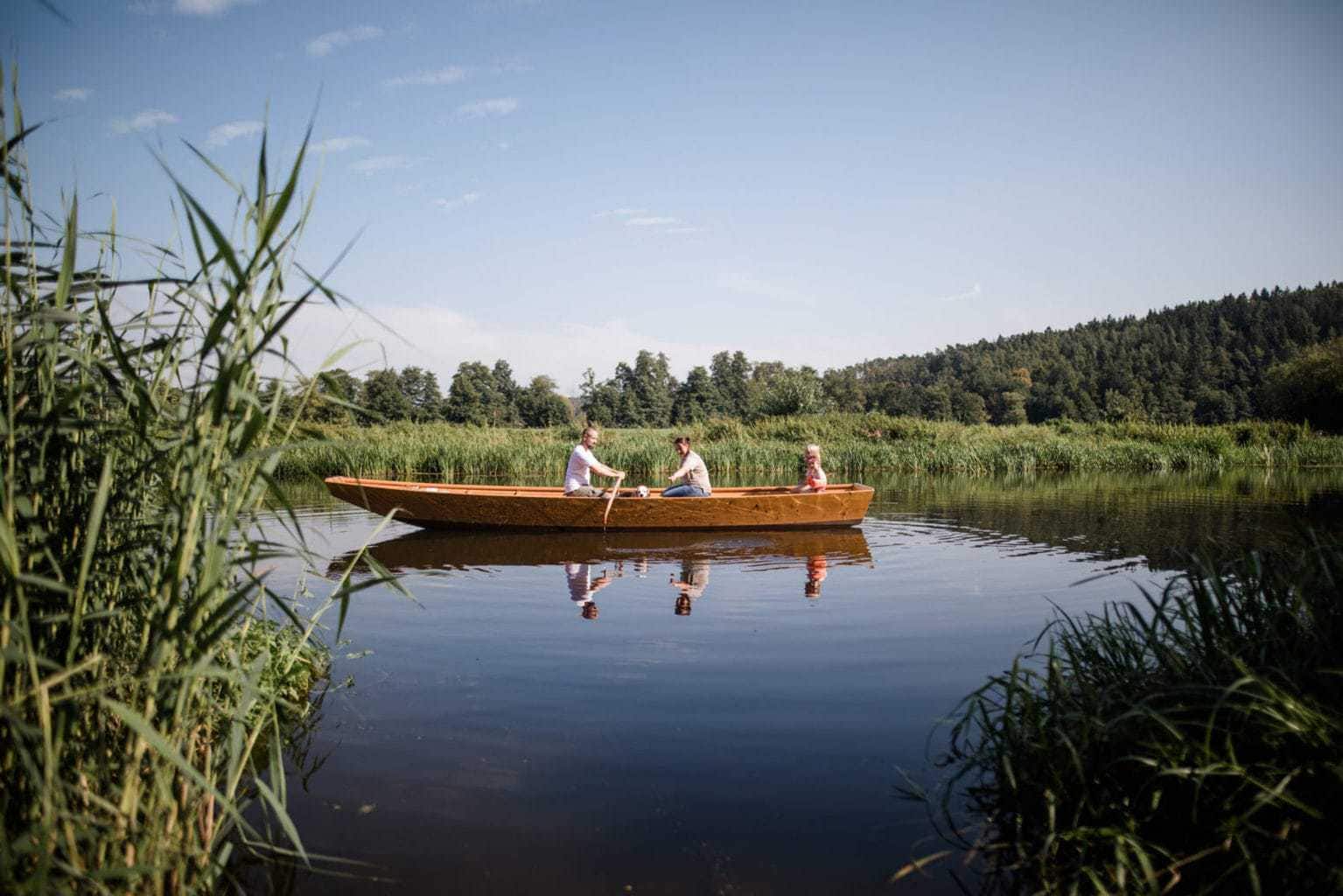 Een familie roeit in een boot in de buurt van vakantieboerderij Simmernhof in het Beierse Mossendorf