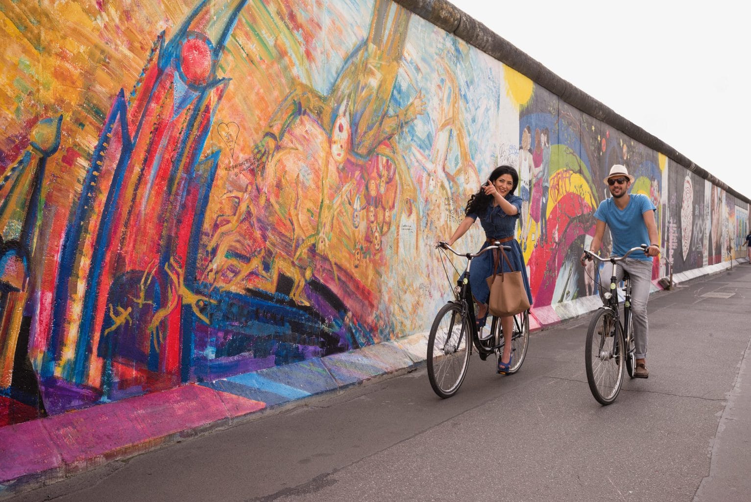 Spaanse touristen fietsen langs de East Side Gallery in Berlijn