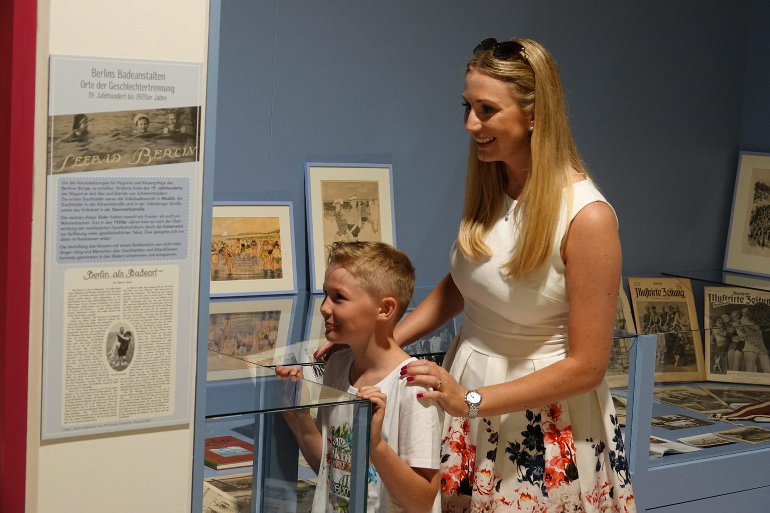 Mutter und Kind blicken interessiert auf die Exponate im Bikini Art Museum