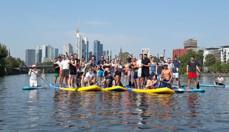 Stand-up-Paddle op de rivier Main voor de Skyline van Frankfurt