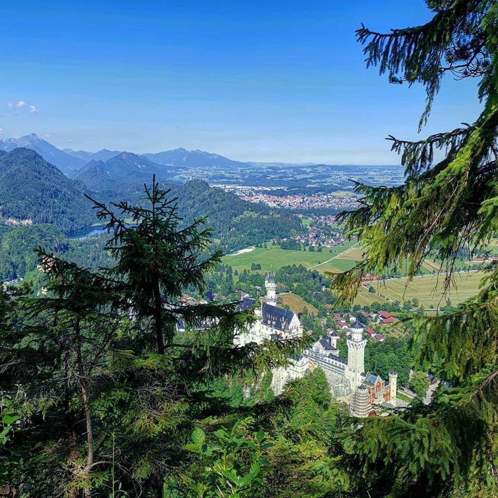 Het beroemde kasteel Neuschwanstein van boven. Koning Ludwig II (1845 – 1886) kwam naar de bergen om de rest van de wereld te ontvluchten. Rond de Zugspitze, langs de Königswanderwege, zijn talrijke plekken die aan hem herinneren. Wil je meer ervaren over deze plekken? Lees verder op onze website in het artikel ‘De Königswanderwege en het leven van Ludwig II’. 🙌  #beieren #koningludwig #ludwigii #neuschwanstein #füssen #hohenschwangau #wandelen #natuur #uitzicht #wow #duitsland #reizen #ontdekken #oppad #sportief #tegelberg #actievevakantie #wanderlust #daswandernistdesmüllerslust #disneycastle #mooiuitzicht #whataview