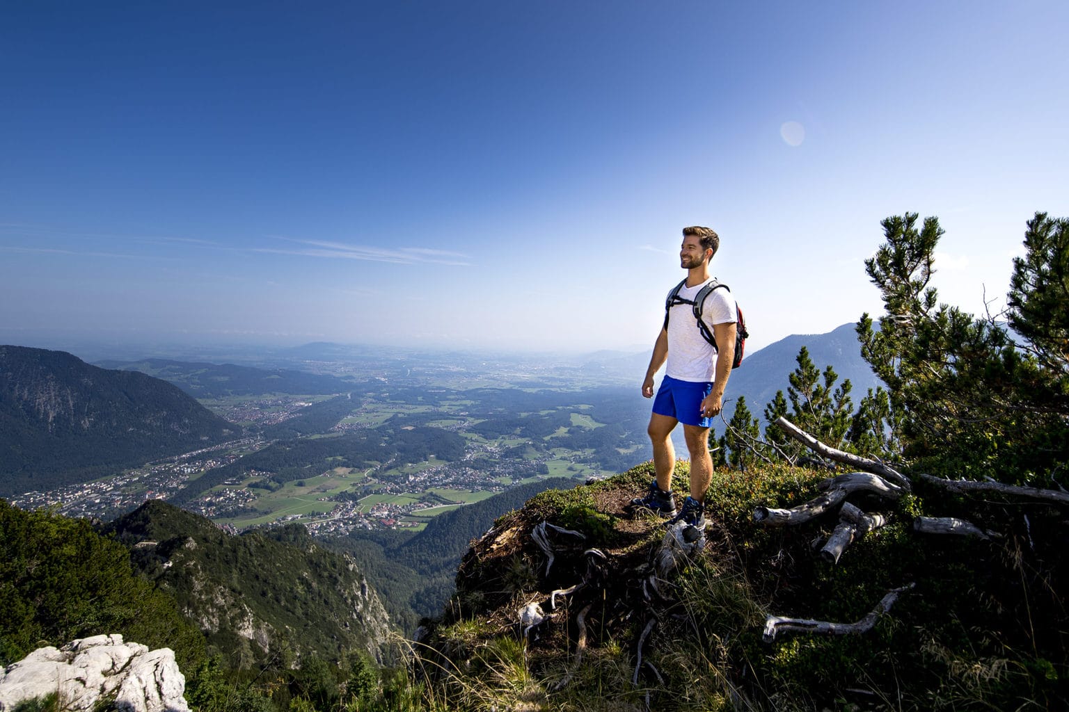Een man lacht over beide bekken na de beklimming van een berg in het Berchtesgadener Land