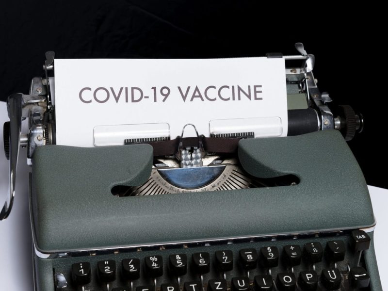 Een schrijfmaschine met een blad papier geeft hoop op een vaccin tegen covid-19
