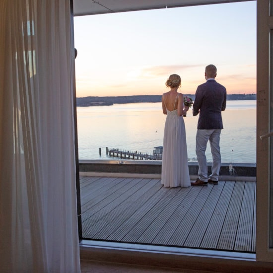 Verliefd stel op het terras bebijkt zonsondergang aan de Oostzee