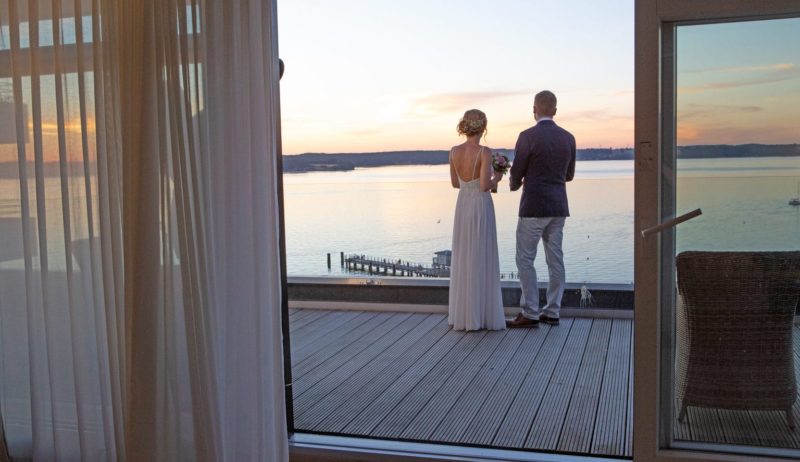 Verliefd stel op het terras bebijkt zonsondergang aan de Oostzee