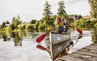 Een vrouw en een man samen in een kano op een meertje in het Beierse Woud in Duitsland