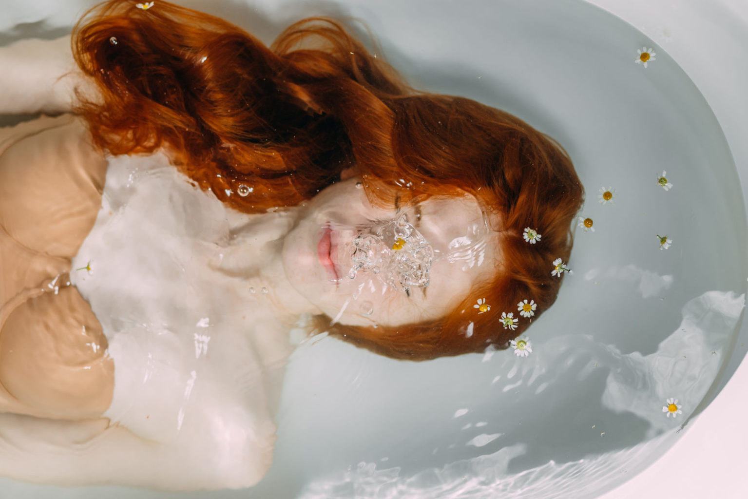 Een vrouw onder water in de badkuip tijdens een Kneipp-therapie thuis