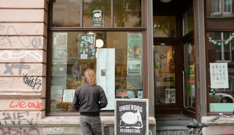 Een jonge man voor de etalage van Underdog Records in Keulen