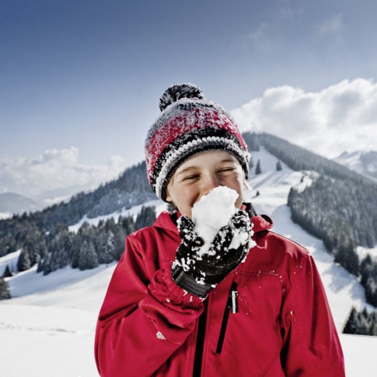 Een kind met een sneeuwbal in de Allgäuer Hörnerdörfer