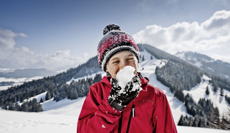 Een kind met een sneeuwbal in de Allgäuer Hörnerdörfer
