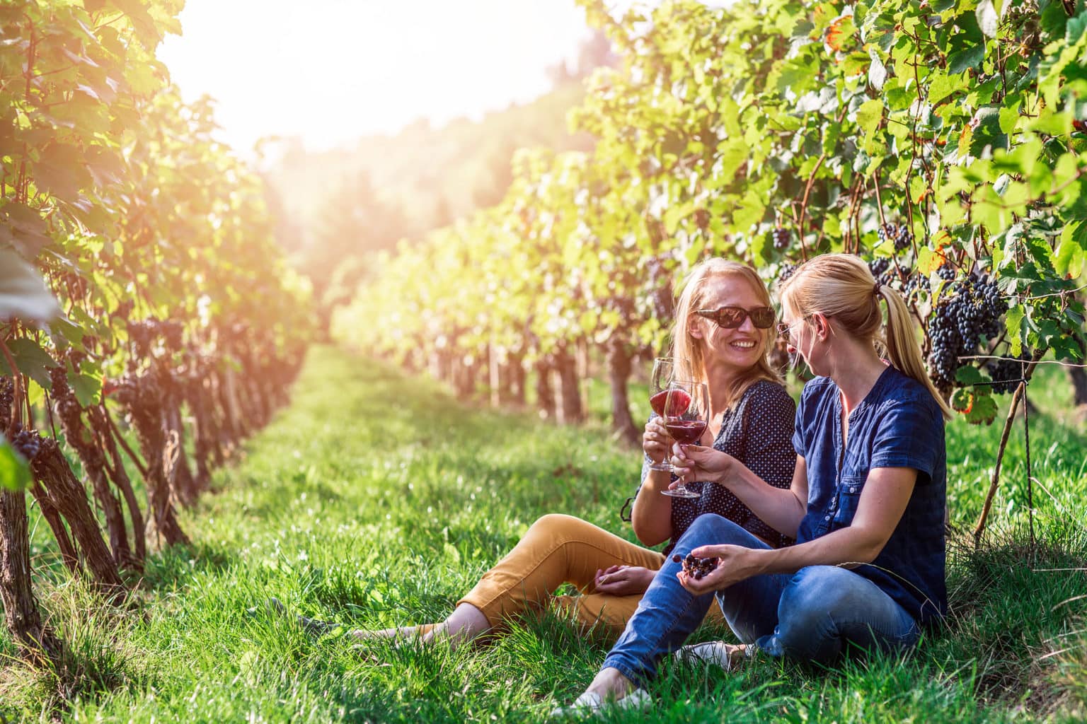 Twee vrouwen drinken wijn tussen de wijnstokken in de regio Saale-Unstrut in het oosten van Duitsland