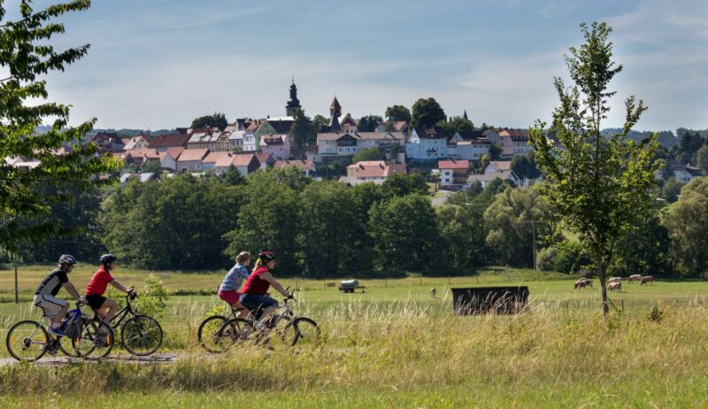 Fietsers op het vulkaanfietspad met ondermeer een kerktoren op de achtergrond