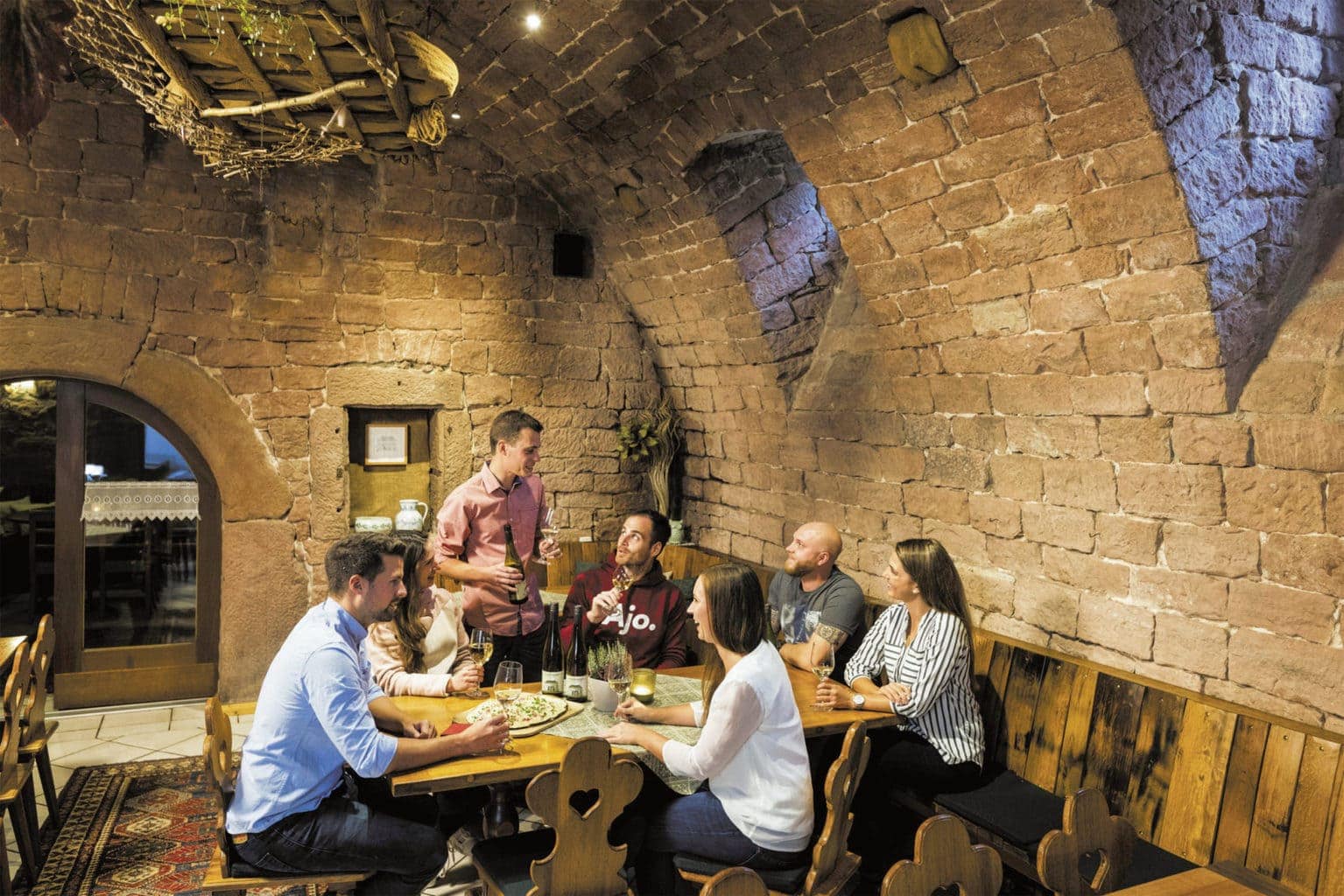 Loon na werken: wandelaars eten en drinken na een wandeling in een kelderrestaurant in Bad Bergzabern in de Palts