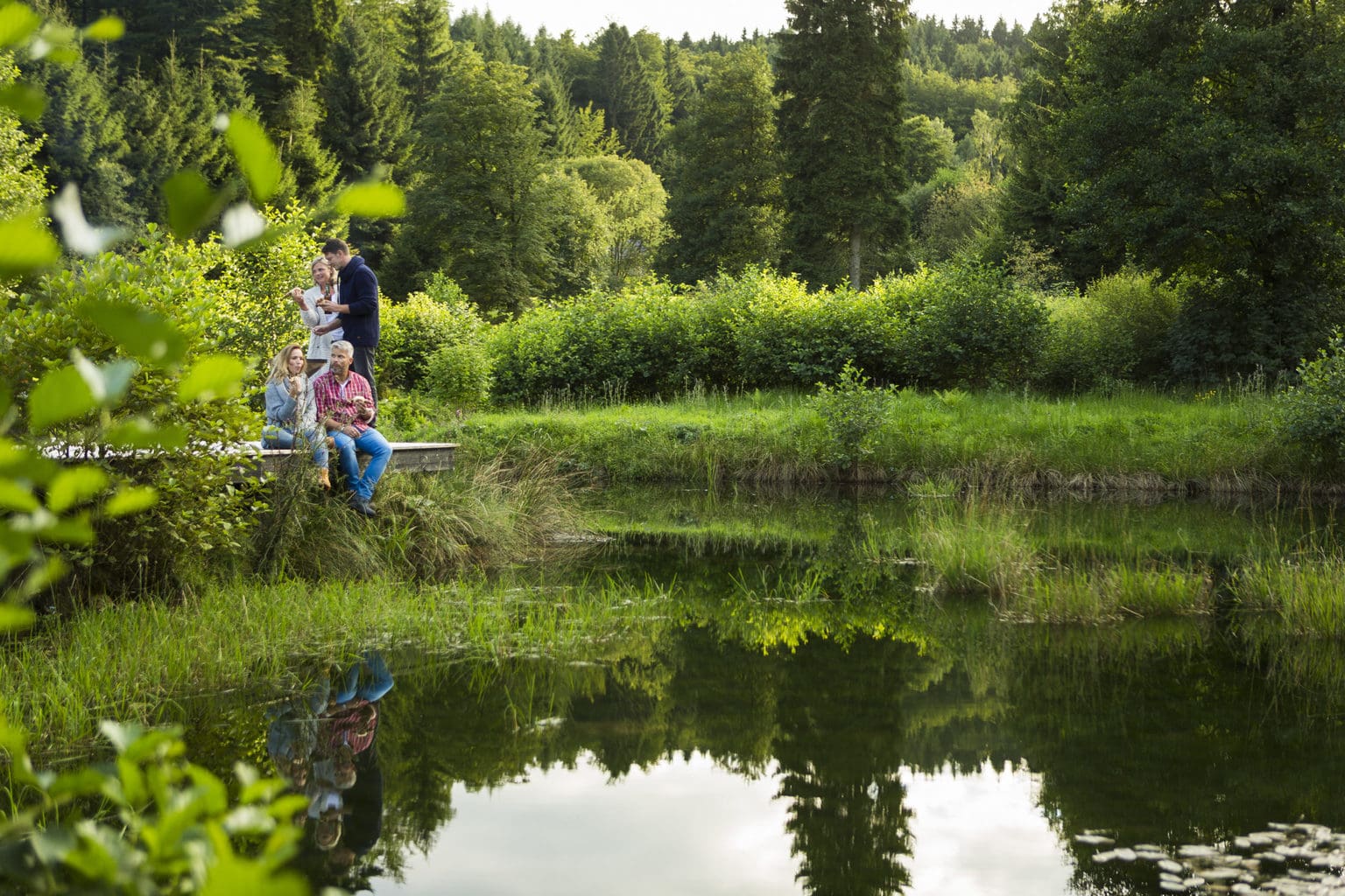 Wandelaars aan een meertje in Thüringen op zoek naar geneeskundige kruiden
