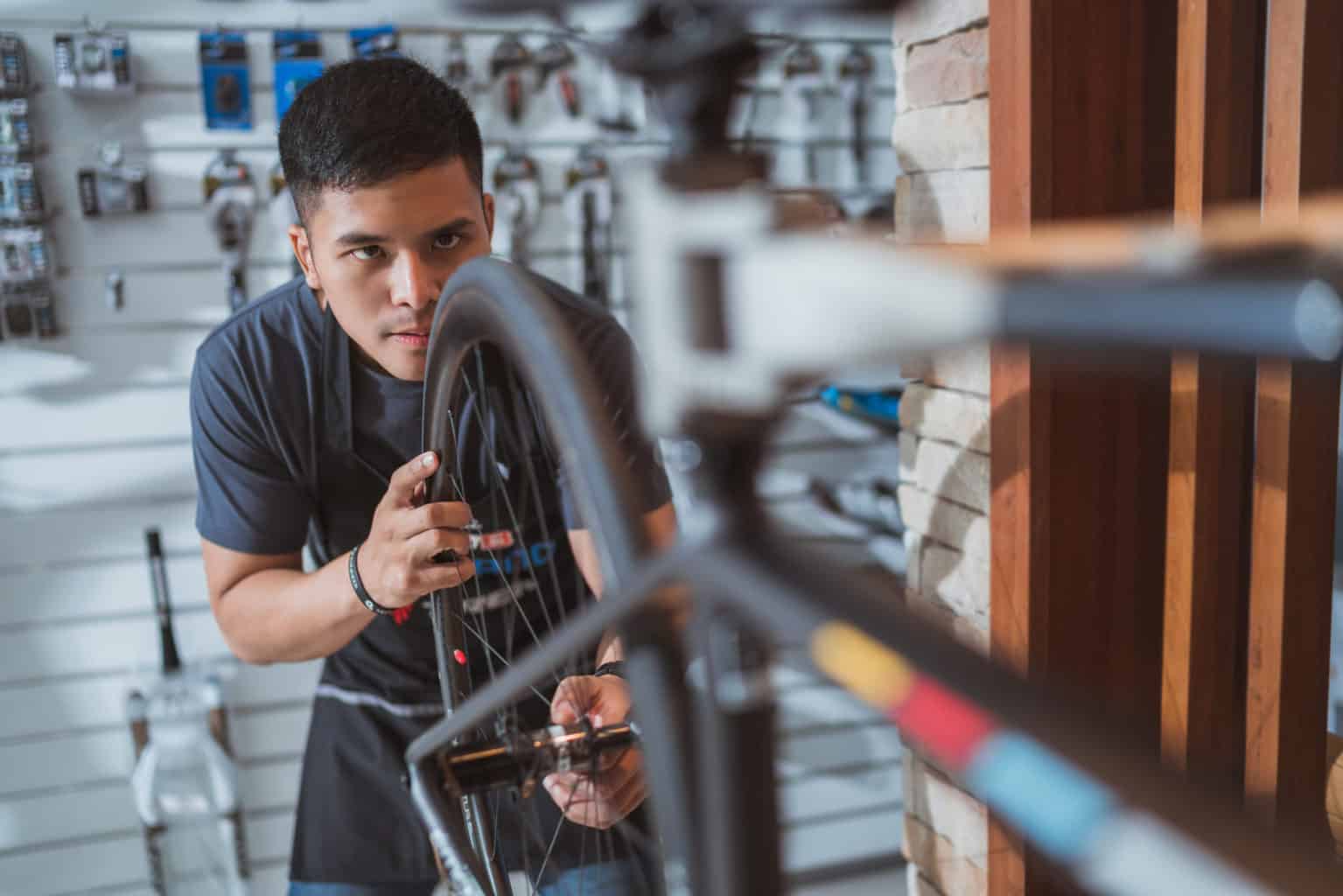 Een jonge man repareert een fiets
