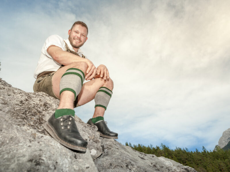 Een man draagt Beierse schoenen op een rots