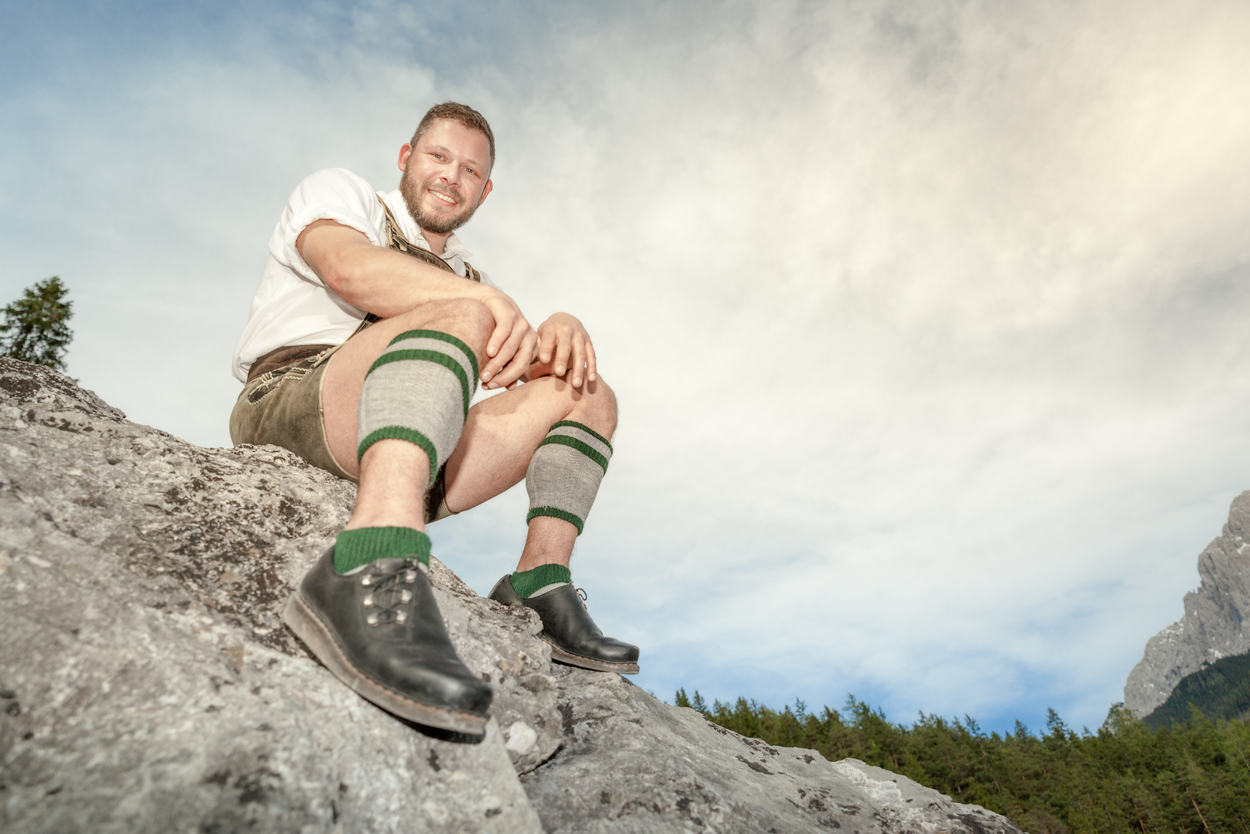 Een man draagt Beierse schoenen op een rots
