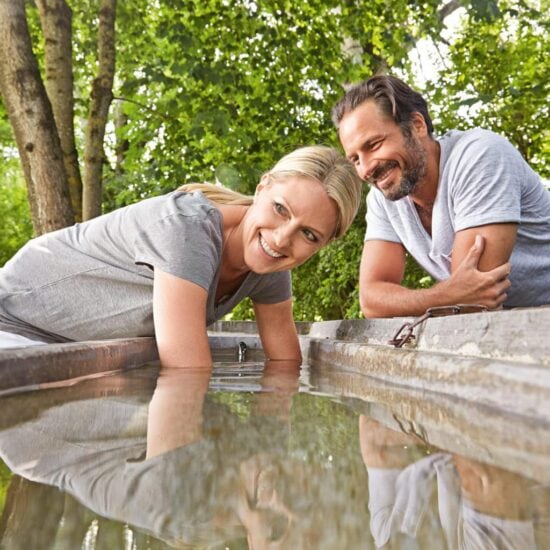 Man en vrouw nemen een armbad in koud water in Bad Wörishofen in Beieren