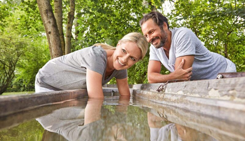 Man en vrouw nemen een armbad in koud water in Bad Wörishofen in Beieren