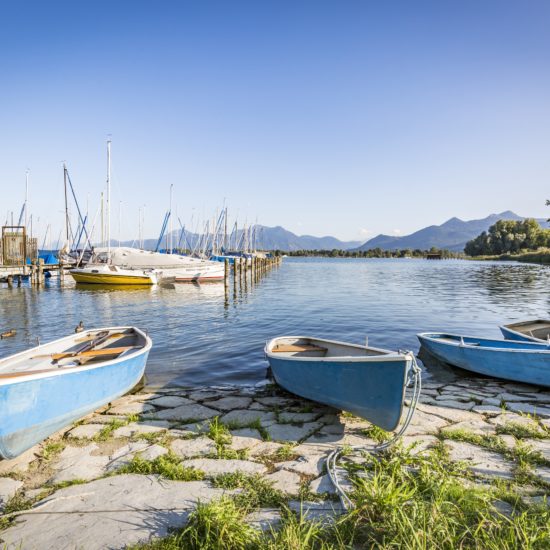Visersboten aan de oevers an de Chiemsee met op de achtergrond de bergen