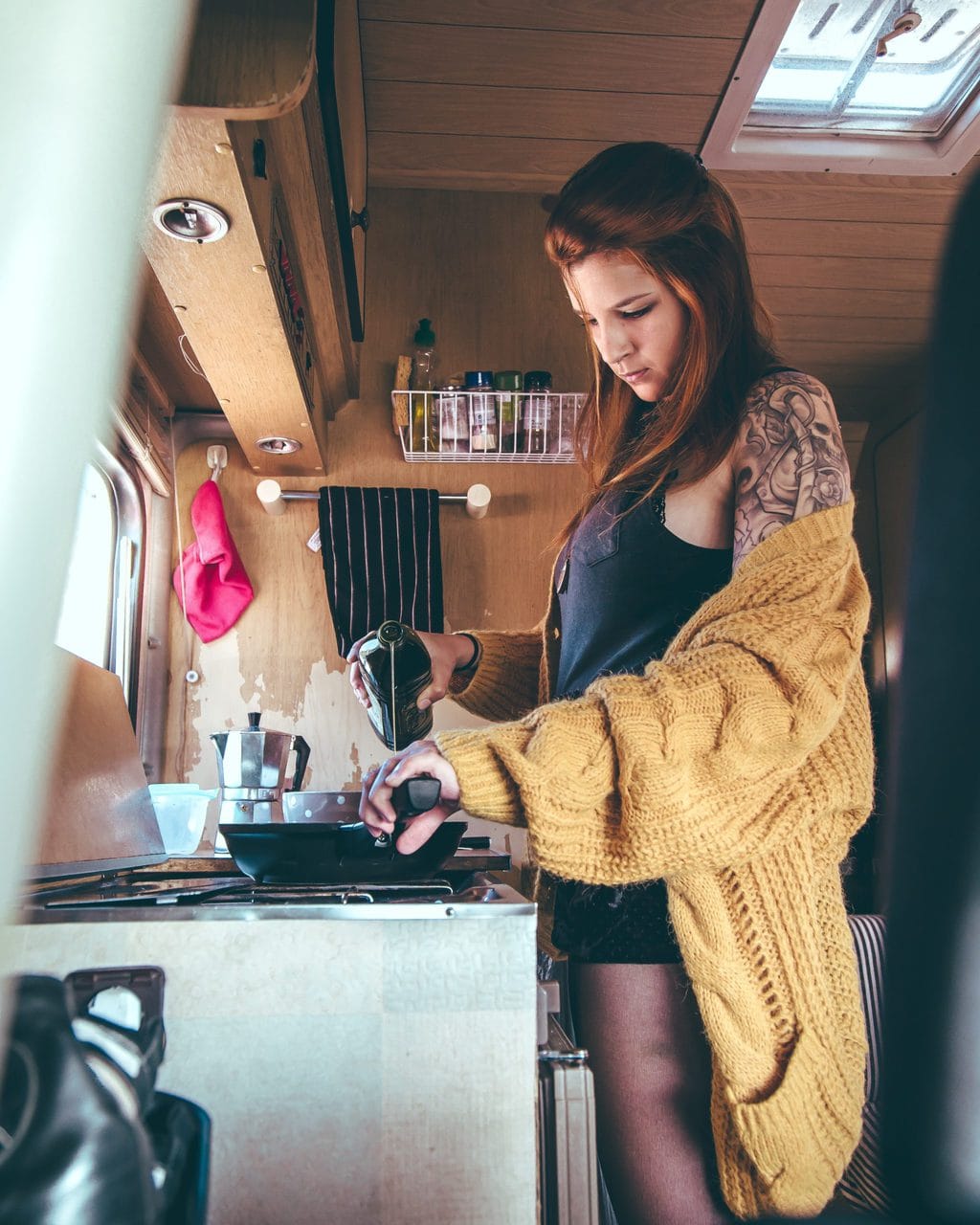 vrouw kookt in een campervan