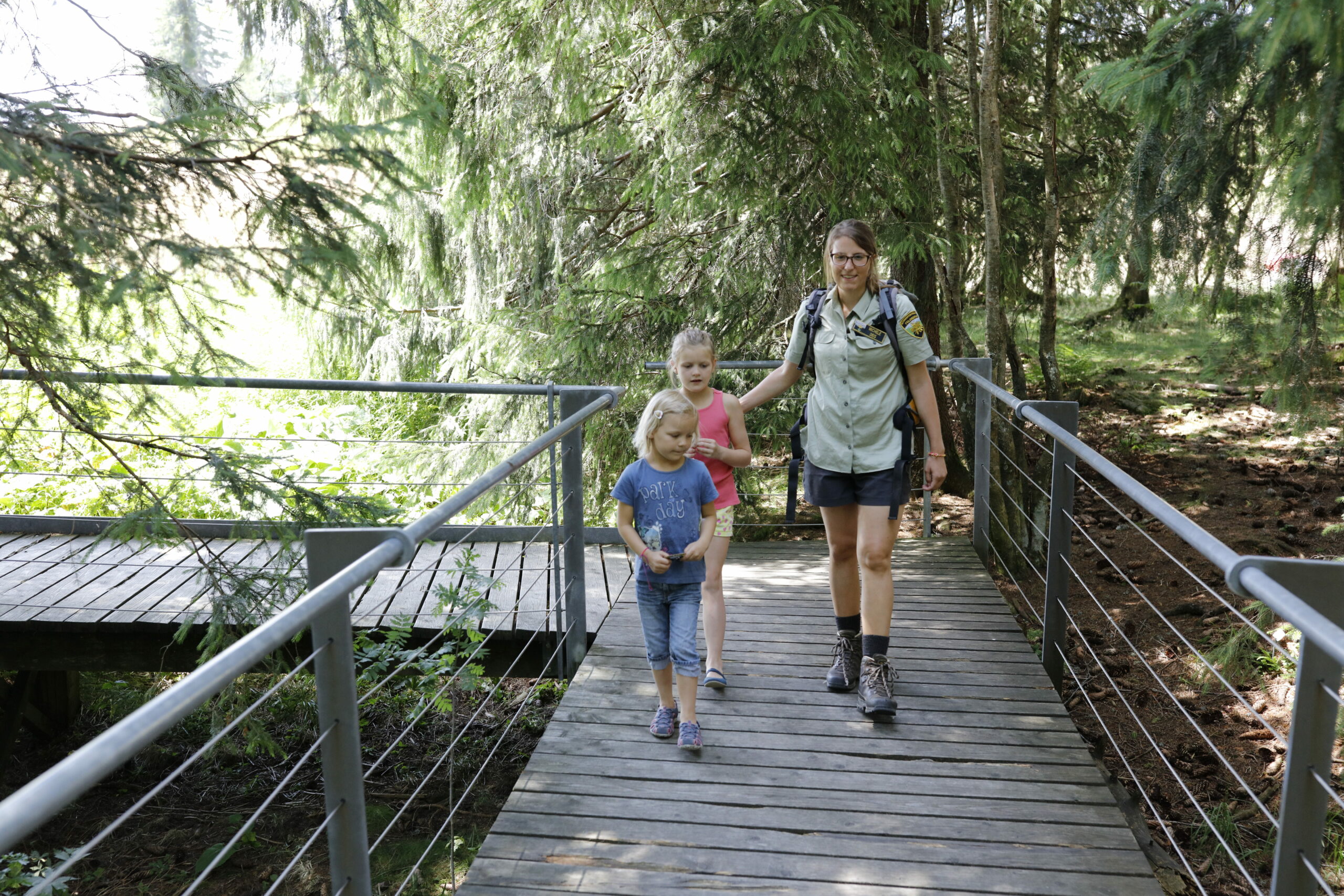 Vrouw en kinderen wandelen op planken door het Schwarzwald