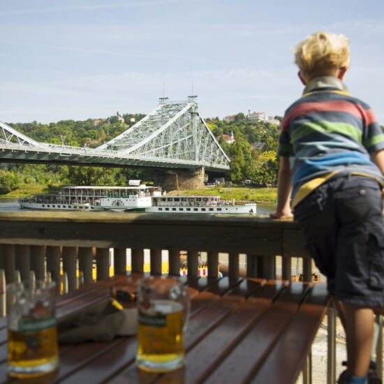 Een kleine jongen kijkt geinteresserd naar het Blaue Wunder, een van de mooiste bruggen in Saksen