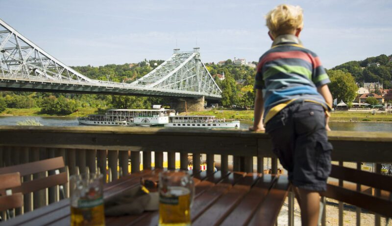 Een kleine jongen kijkt geinteresserd naar het Blaue Wunder, een van de mooiste bruggen in Saksen