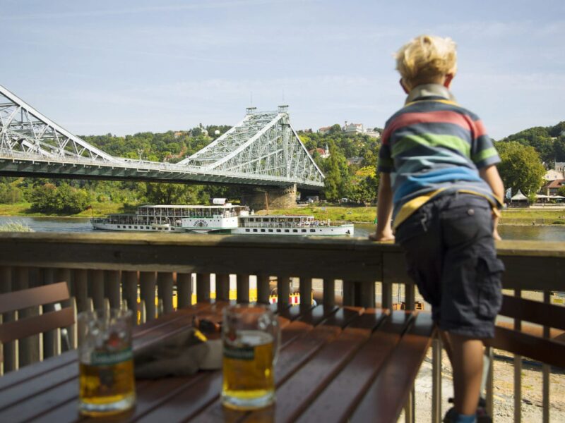 Een kleine jongen kijkt geinteresserd naar het Blaue Wunder, een van de mooiste bruggen in Saksen