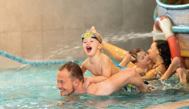 Een familie vermaakt zich in het zwembad