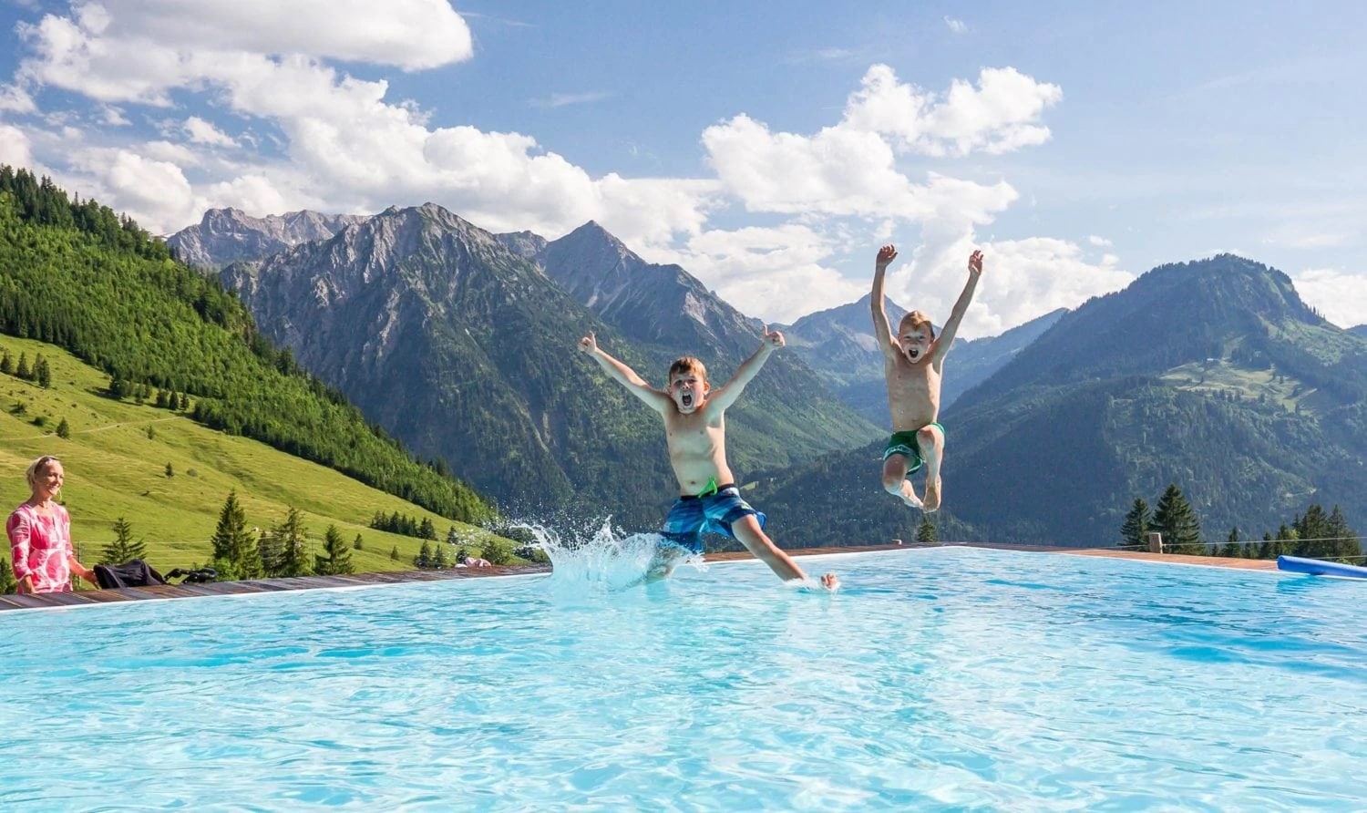 Kinderen springen een zwembad in bij het Oberjach in de Duitse Alpen