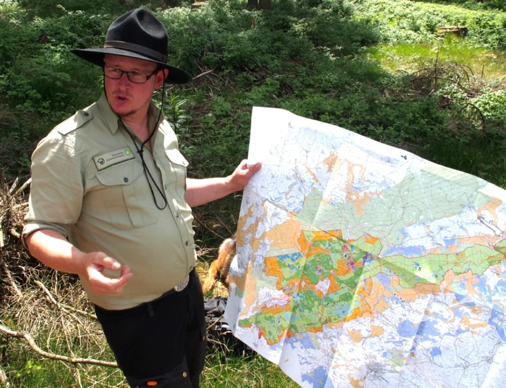 Ranger met plattegrond in Nationaal Park Hunsrück Hochwald in Duitsland