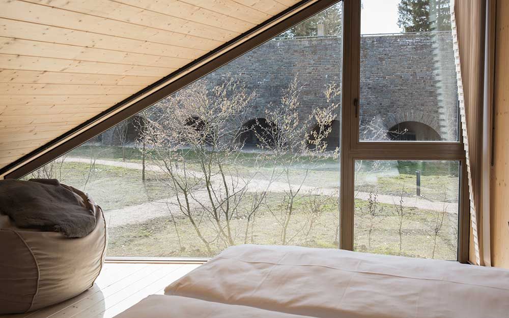 Slaapkamer met uitzicht naar buiten in Cabins von Neugrad in de Eifel