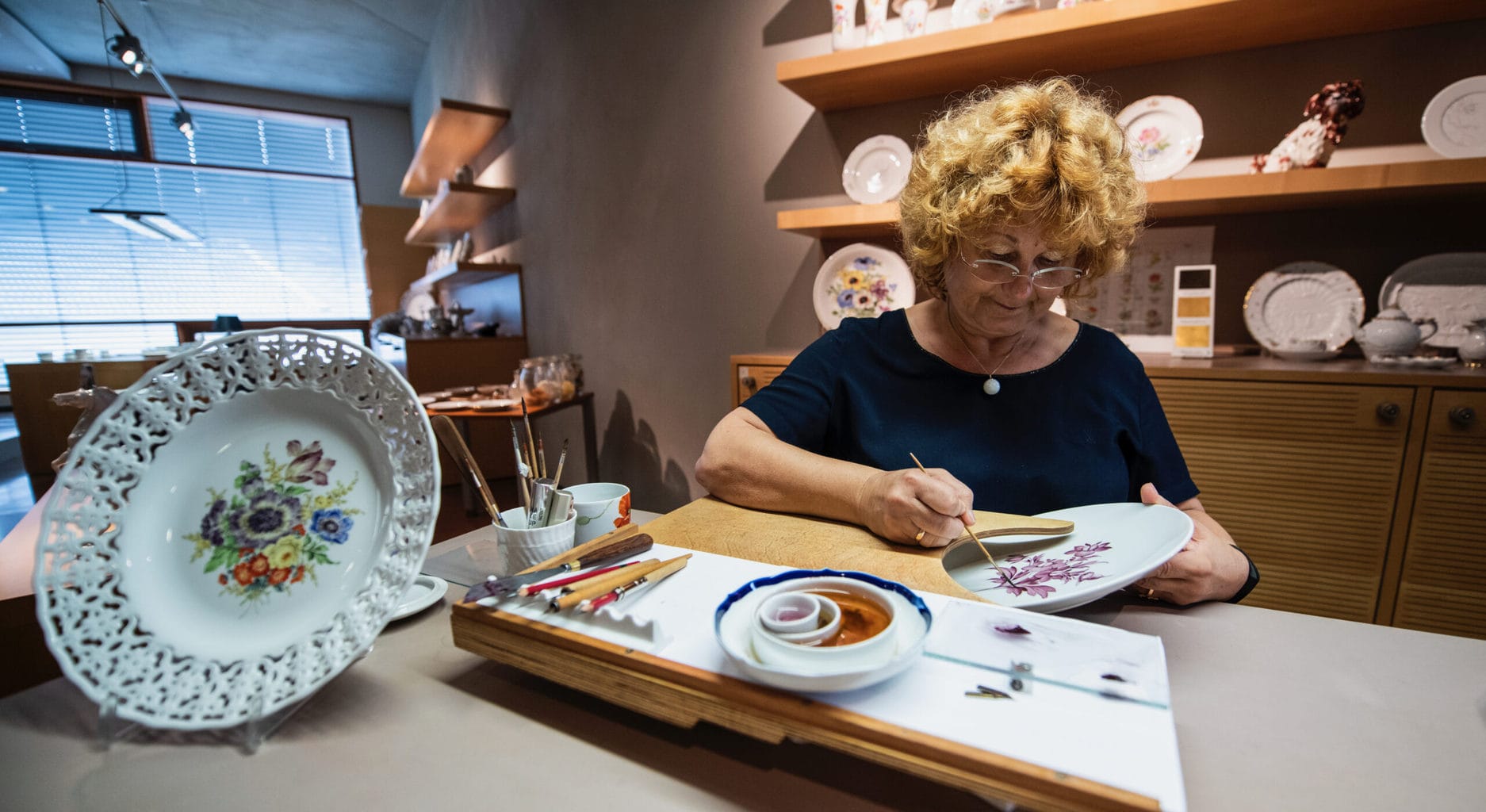 Een vrouw schildert op porselein in een fabriek in het Duitse Meissen