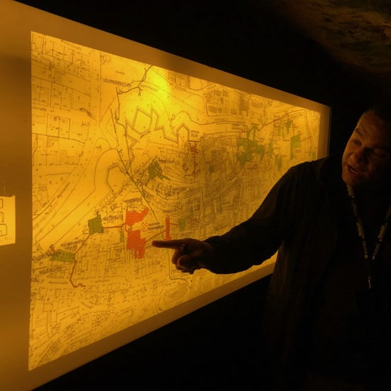 Stadgids Richard Selke laat op de plattegrond zien waar kelders en rotsgangen zijn in Neurenberg