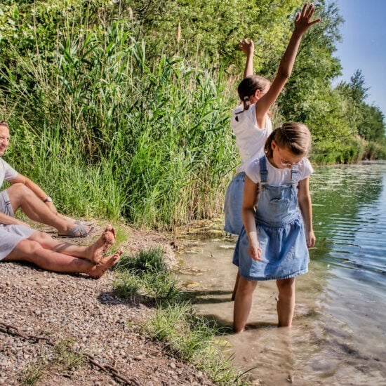 Familie zit op het Rijnstrand en geniet van de zon