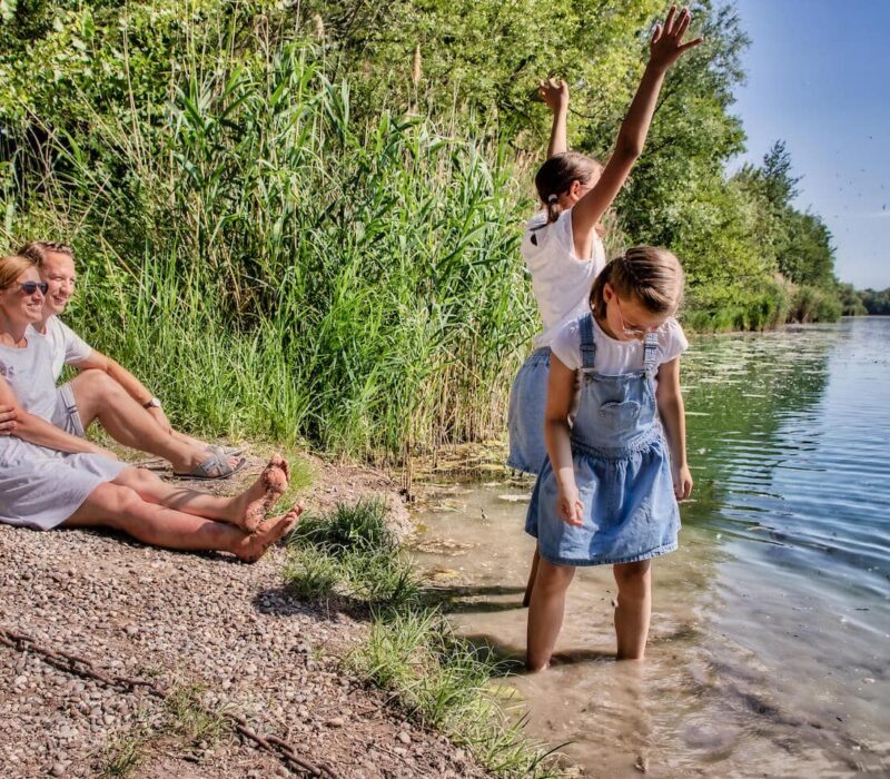 Familie zit op het Rijnstrand en geniet van de zon