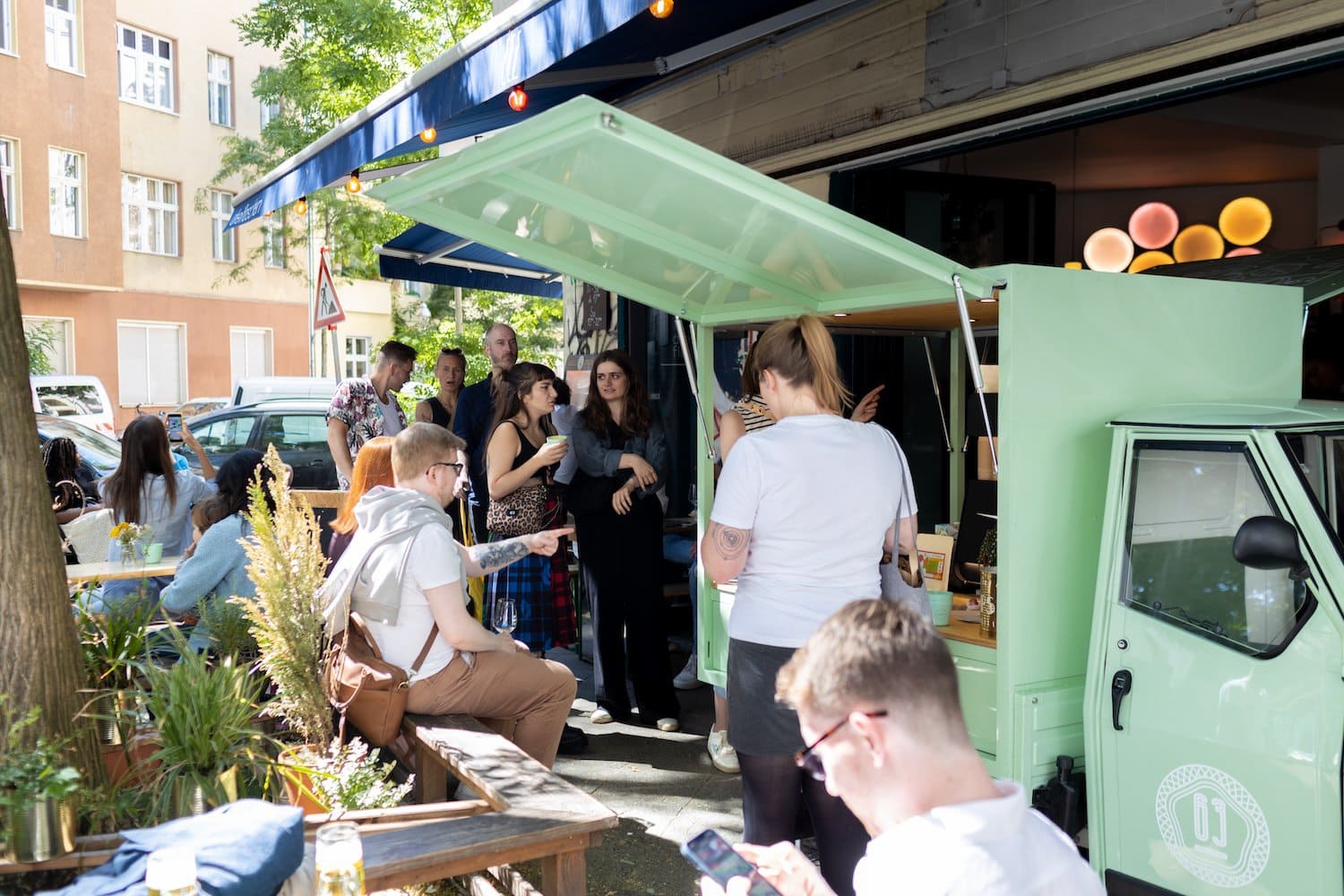 Mensen staan in de rij bij de koffiemobiel van koffiebranderij August 63